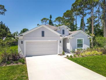 Charming one-story home with a two-car garage, long driveway, and meticulously manicured landscaping at 1314 Victory Palm Dr, Edgewater, FL 32132