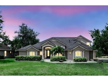 Stunning home with a well-manicured lawn, elegant architectural details, and lush landscaping, creating a welcoming curb appeal at 158 Hickory Stick Ct, Debary, FL 32713