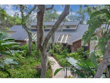 Inviting home featuring a lush, tropical garden and a charming walkway leading to the front entrance at 204 Green Lake Cir, Longwood, FL 32779