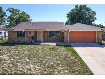 Charming brick single-story home with a two-car garage and well-maintained front yard at 2470 Pine Tree Circle Dr, Orange City, FL 32763