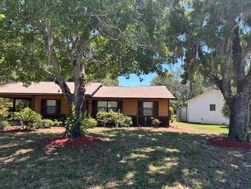 Charming single-story home featuring mature trees and tidy landscaping at 35 Aberdeen Cir, Leesburg, FL 34788