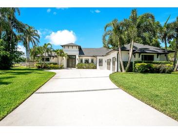 Elegant home with lush landscaping, expansive driveway, and modern architectural details at 4210 Waterfront Pkwy, Orlando, FL 32806