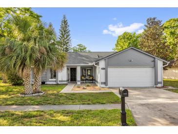 Charming single-story home with well-maintained lawn, palm trees, and a cozy front porch seating area at 4918 Gifford Blvd, Orlando, FL 32821