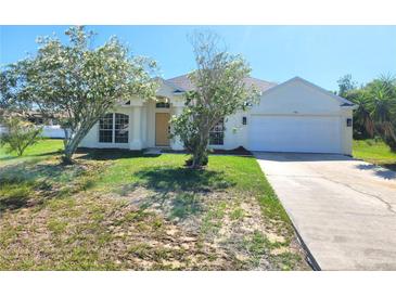 Charming single-story home featuring a well-maintained lawn, attached garage, and inviting front entrance at 506 Peace Way, Kissimmee, FL 34759