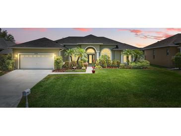 Charming single-story home boasts lush landscaping, mature palms, and a well-manicured lawn at 6758 Hillis Dr, Lakeland, FL 33813