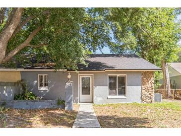 Charming single story home featuring stone accents, mature landscaping, and a cozy front porch at 3673 Westland Ct, Orlando, FL 32818
