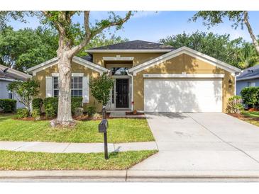 Charming single-story home with a well-manicured lawn, mature trees, and a two-car garage at 1174 Snug Harbor Dr, Casselberry, FL 32707