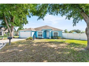Charming single-story home with blue exterior, well-maintained lawn, and a two car garage at 134 Foggy Creek Ct, Davenport, FL 33837