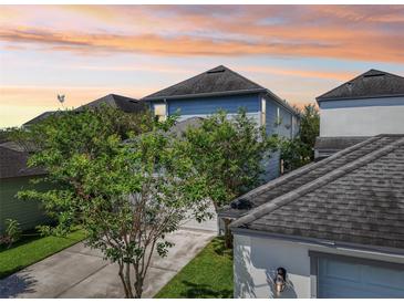 Two-story home featuring light blue siding, a gray roof, and mature landscaping at 13890 Sato Ave, Orlando, FL 32827