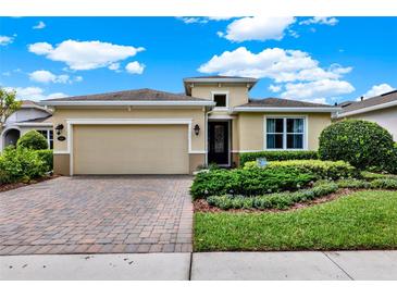 Charming single-Gathering home featuring a brick driveway, two-car garage, and manicured landscaping at 1424 Palisades Lane, Deland, FL 32724