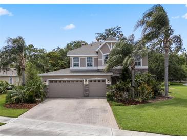 Two-story home featuring a three-car garage and manicured landscaping at 14315 Hampshire Bay Cir, Winter Garden, FL 34787