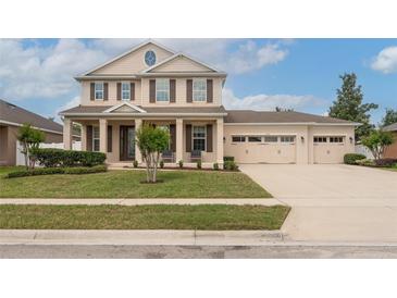 Beautiful two-story home with a manicured lawn and a three-car garage at 1710 Alejo Dr, Apopka, FL 32712