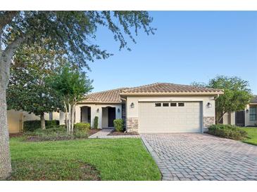 Charming single-story home with tile roof, stone accents, well-manicured lawn and brick paver driveway at 307 Monterey St, Kissimmee, FL 34759