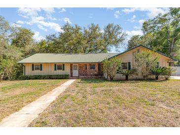 Charming single-story home with a metal roof and a well-maintained front yard at 360 Westchester Dr, Deland, FL 32724