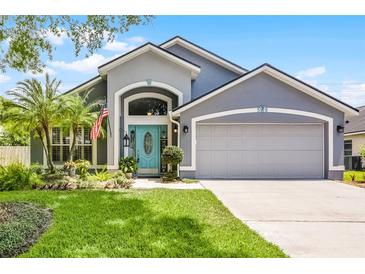 Charming home featuring a well-manicured lawn and a bright, inviting turquoise front door at 578 Darkwood Ave, Ocoee, FL 34761
