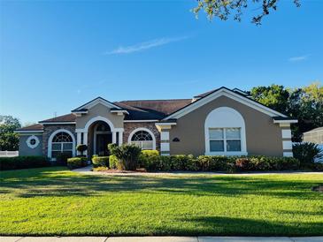Well-manicured lawn and landscaping enhance the curb appeal of this home at 702 Palenci Ct, Winter Springs, FL 32708