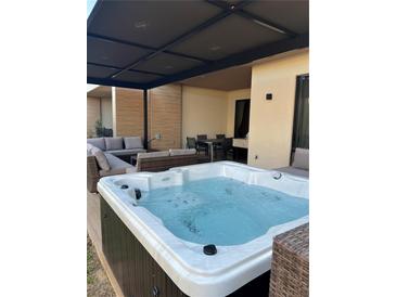Inviting hot tub with lounge seating and dining area under a covered patio at 7567 Brooklyn Dr, Kissimmee, FL 34747