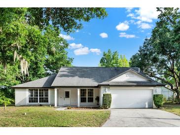 Charming single-story home featuring a well-maintained lawn and attached two-car garage at 9290 Lake Sharp Ct, Orlando, FL 32817