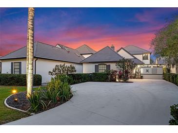 Beautiful exterior elevation of home with a circular drive, landscaping, and a stunning sunset sky at 9624 Bryanston Dr, Orlando, FL 32827