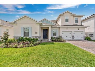 Charming two-story home featuring a well-manicured lawn, beautiful landscaping, and a three-car garage at 19334 Banfield Pl, Orlando, FL 32827