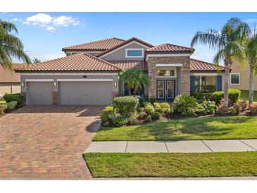 Beautiful home with a tile roof, brick driveway and tropical landscaping in the front yard at 1945 Via Lago Dr, Lakeland, FL 33810