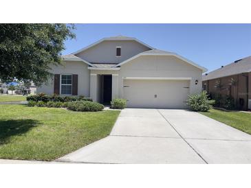 Charming one-story home featuring a well-manicured lawn and a two-car garage at 271 Tanglewood Dr, Davenport, FL 33896