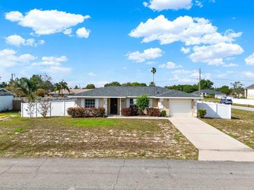 Charming single-story home with a well-manicured front yard, long driveway, and a white picket fence at 2764 W Covington Dr, Deltona, FL 32738