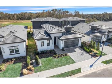Contemporary two-story home featuring well-manicured lawn, stone accents, and a two-car garage in a desirable community at 3024 Kensington Ave, Davenport, FL 33837