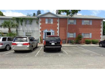 Traditional two-story brick apartment building with ample parking spaces and manicured landscaping at 3060 George Mason Ave # 10C, Winter Park, FL 32792