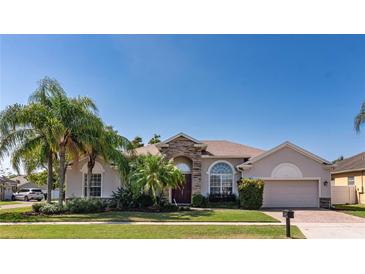 Charming single-story home with stone accents, manicured lawn, and lush landscaping, creating an inviting curb appeal at 3436 Herringridge Dr, Orlando, FL 32812