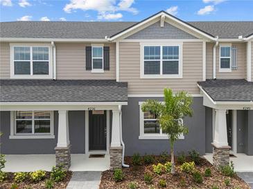 Charming townhouse featuring a well-manicured lawn and inviting front entrance with decorative stone pillar accents at 4236 Sadler Rd, Apopka, FL 32712