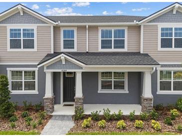Charming two-story townhome featuring a welcoming front porch and well-maintained landscaping at 4244 Sadler Rd, Apopka, FL 32712