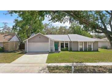 Charming home featuring a well-maintained front yard, driveway, garage, and a welcoming front door at 5163 Lighthouse Rd, Orlando, FL 32808