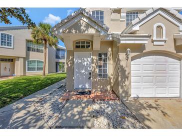 Charming front entrance featuring a white door, tiled entry, and well-maintained landscaping at 7021 Della Dr # 52, Orlando, FL 32819