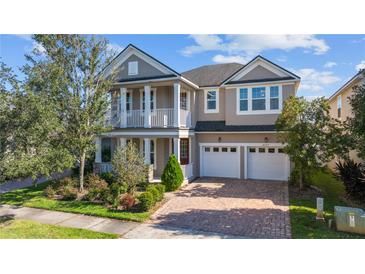 Charming two-story home with a brick driveway, a two-car garage, and a lovely second story balcony at 8565 Tallfield Ave # 1, Orlando, FL 32832