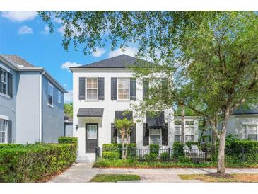 Charming two-story home with black shutters, a landscaped yard, and shade trees at 1117 Damask St, Celebration, FL 34747