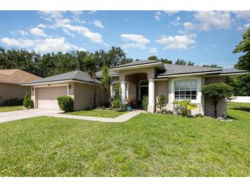 Beautiful single-story home featuring a manicured lawn and an attached two-car garage at 11506 Clair Pl, Clermont, FL 34711