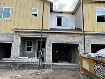 Unfinished exterior of a townhouse with block and siding construction, awaiting completion at 14934 Harvest St, Orlando, FL 32824