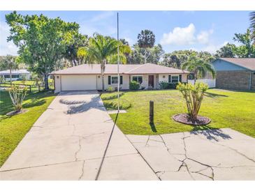 Charming single-story home featuring a lush front yard, long driveway, and attached garage at 1617 Hontoon Rd, Deland, FL 32720