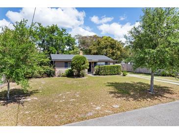 Charming single-story home with brick accents, a well-maintained lawn, and mature trees creating curb appeal at 1821 Goodrich Ave, Winter Park, FL 32789