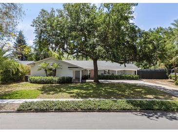 Charming single-story home featuring a lush front yard, mature trees, and a covered entrance at 2004 Mohawk Trl, Maitland, FL 32751