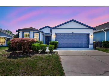 Charming single Gathering home featuring a two-car garage, well manicured lawn, and unique blue trim at 2308 Glenbrook Chase Blvd, Lakeland, FL 33811