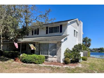 Two-story home with white siding, brick accents, bay window, and mature landscaping at 240 Slade Dr, Longwood, FL 32750