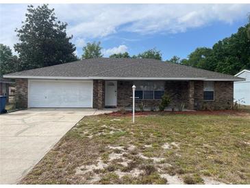 Charming single-story brick home with attached garage and well-maintained front yard at 2435 W Park Dr., Deland, FL 32724