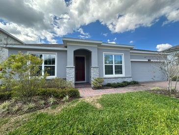 Charming single-story home featuring a well-manicured lawn and a welcoming front entrance with stone accents at 2741 Nottel Dr, St Cloud, FL 34772