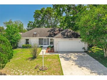 Charming single-story home with a well-manicured lawn and mature trees, providing shade and curb appeal at 3205 Clewiston St, Deltona, FL 32738