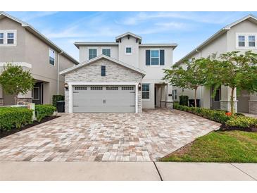 Charming two-story home with a stone accented garage and paver driveway at 416 Southfield St, Kissimmee, FL 34747