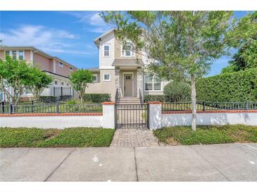 Charming two-story home with manicured lawn, brick accents, and a secure, decorative black metal fence at 441 N Capen Ave, Winter Park, FL 32789