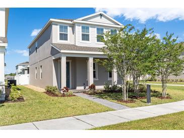 Charming two-story home featuring a landscaped front yard with fresh green grass and healthy trees at 779 Firerock Ln, Debary, FL 32713