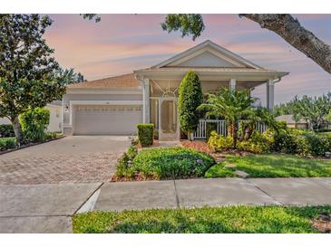 Charming single-story home with a screened porch, two-car garage, and lush landscaping at 115 Crescent Moon Dr, Groveland, FL 34736